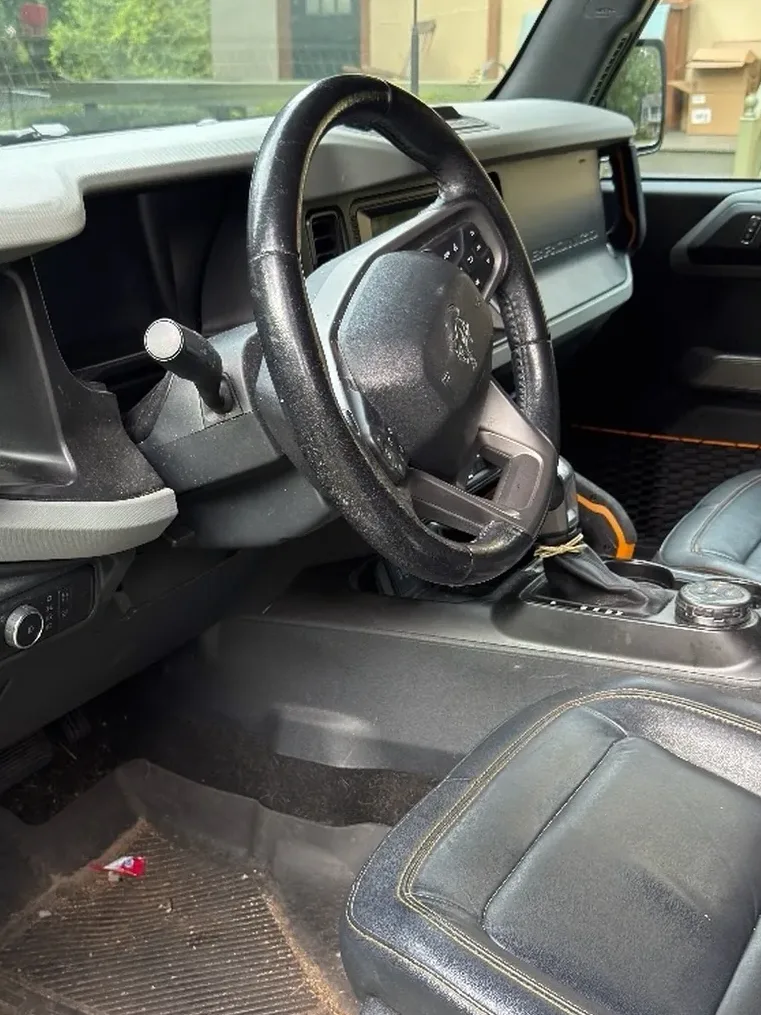 Ford Bronco front cabin before detailing, with dirt on the floor mat and seat